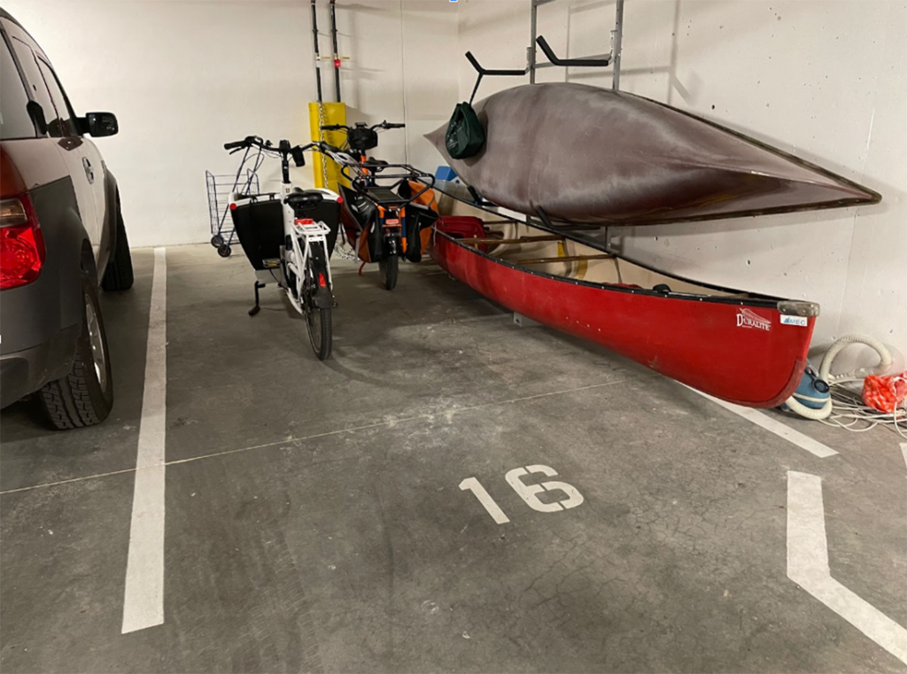 A parking space at the Little Mountain Cohousing full of recreational gear including bikes and canoes (instead of a car).