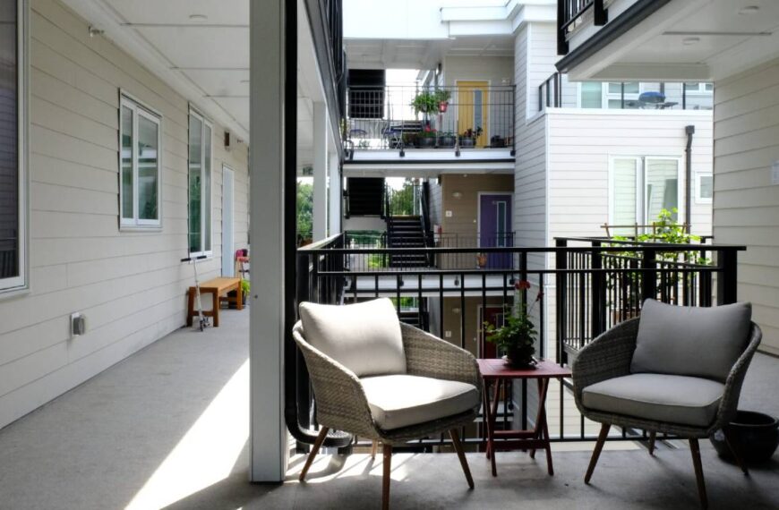 Wide, exterior walkways at Driftwood Village Cohousing in North Vancouver are lined with differently coloured doorways, windows, plants, and seating.
