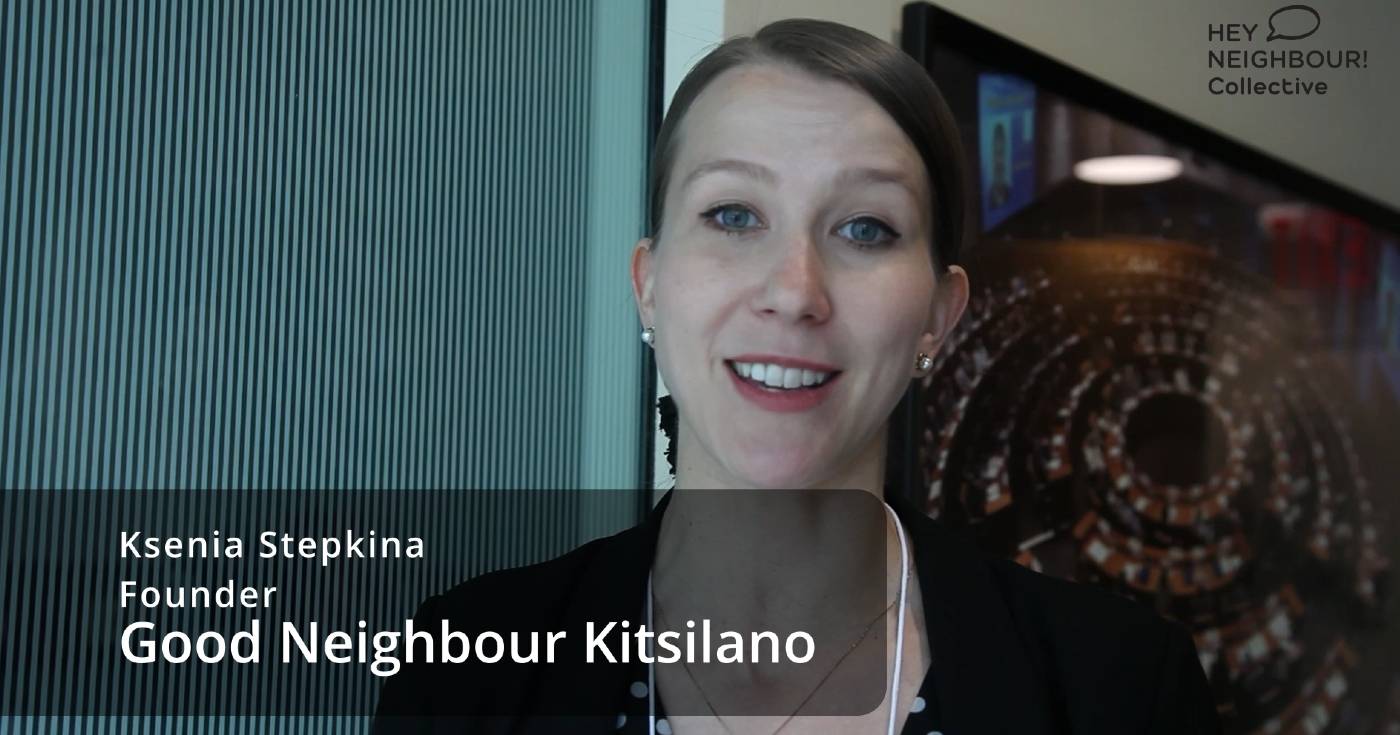 Ksenia Stepkina looks at the camera while being interviewed in this still excerpt from a video. Text is overlaid with her name and her title, "Founder, Good Neighbour Kitsilano."