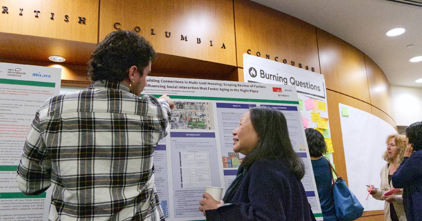 Jean Paul speaks with a participant at the Living Together Symposium in May 2025.