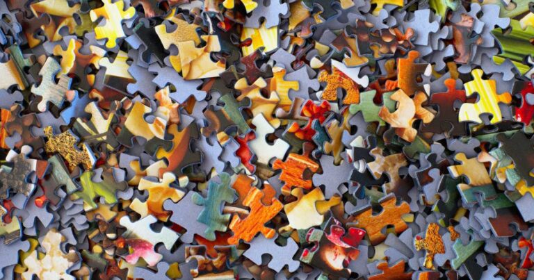 A top-down view of a pile of puzzle pieces.