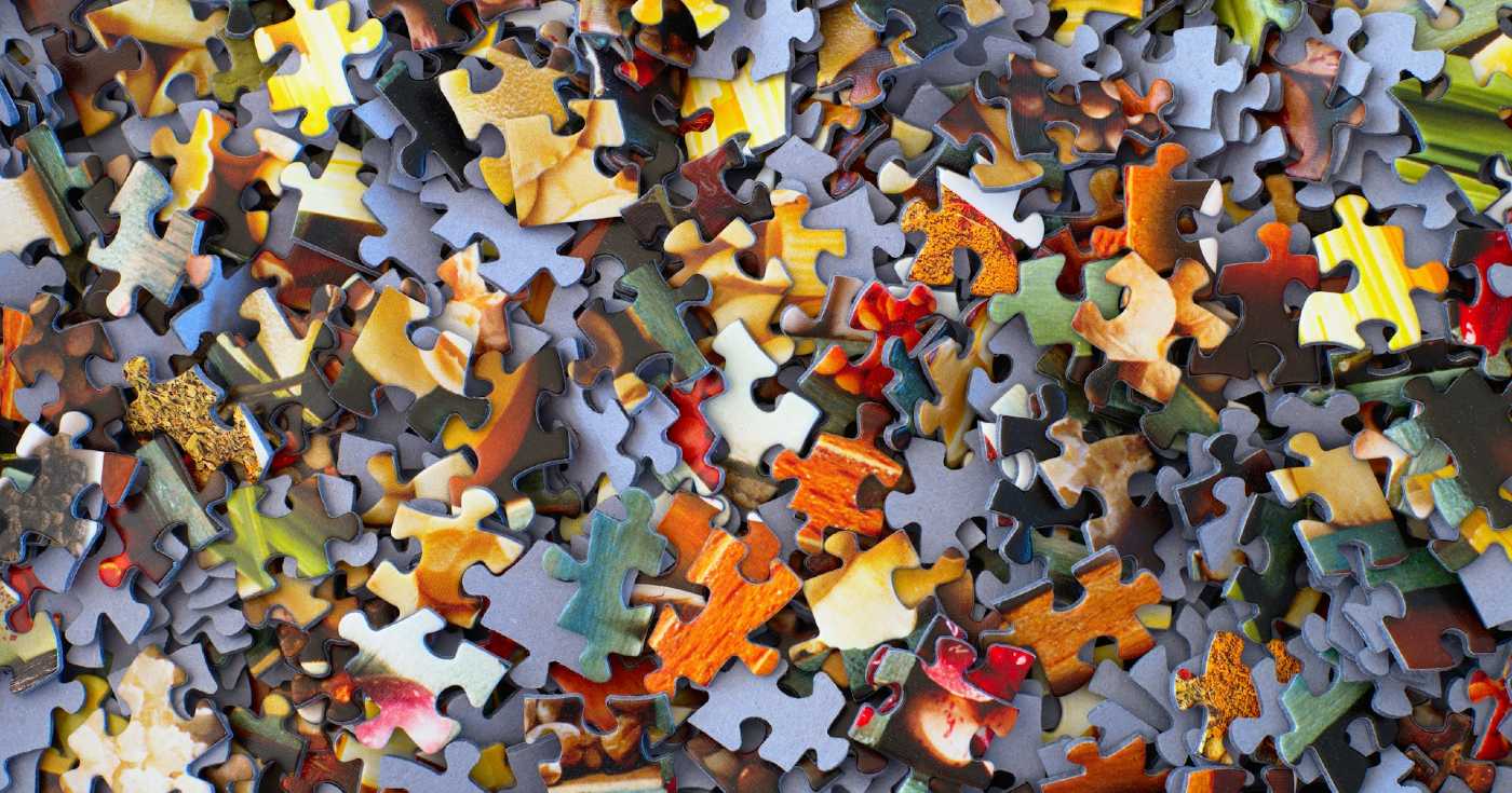 A top-down view of a pile of puzzle pieces.